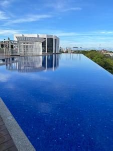 a large pool of blue water in front of a building at Rizz Residence Troika KB in Kota Bharu