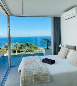 a bedroom with a large white bed and a large window at La Suite Del Mar in Gran Alacant
