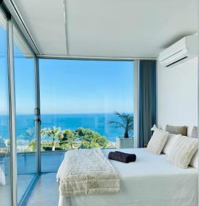 1 dormitorio con 1 cama blanca grande y ventana grande en La Suite Del Mar, en Gran Alacant