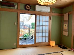 Camera con porta scorrevole in vetro e vista su un patio. di OTERA HOUSE 瑞　TAMA ad Osaka