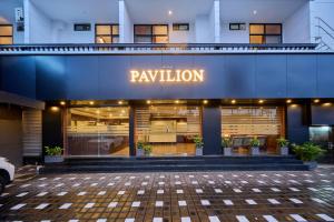 un edificio con un letrero que lee la paga en Nettoor Pavilion, en kumbalam