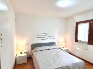 1 dormitorio con 1 cama con 2 mesitas de noche y 2 lámparas en Garden Thermae, en Nago-Torbole