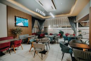 un restaurante con mesas y sillas y TV en la pared en Grand Quars Hotel en Avcılar