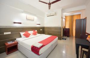 a bedroom with a large white bed with red pillows at Nettoor Pavilion in kumbalam