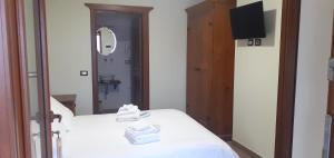 a bedroom with a bed with white sheets and a mirror at Casale Sienti'n Può in Norcia