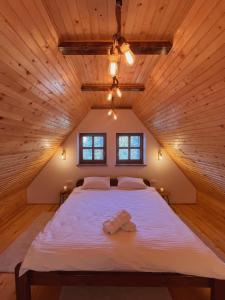 a bedroom with a large bed in a wooden ceiling at Apartmani Astra in Risovac