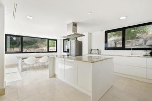 una cucina con armadi bianchi e piano di lavoro di Giga - Luxury paradise, complete silence and sea view a San Roque