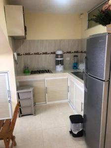a kitchen with a stainless steel refrigerator and white cabinets at Apartamento para 5 in Barranquilla