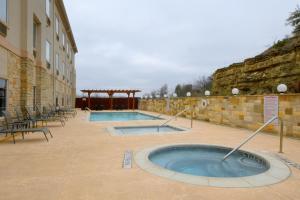 a hot tub in a courtyard next to a building at Baymont Inn & Suites by Wyndham Glen Rose in Glen Rose