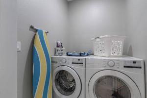a washing machine and a washer in a room at Welcome to Cozy Coastal Cottages of Dunedin #1 in Dunedin