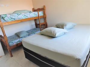 Двох'ярусне ліжко або двоярусні ліжка в номері Apto Aluguel na Temporada Pé na Areia Peruíbe SP