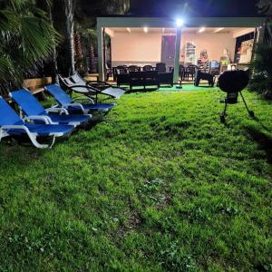 una fila di sedie a sdraio sul prato di notte di Villa Assia a Gaeta