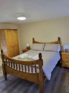 ein Schlafzimmer mit einem großen Holzbett mit Kissen in der Unterkunft Small Town House, Barrow Lane, Bagenalstown, Carlow in Bagenalstown