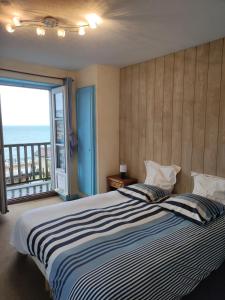 a bedroom with a bed with a view of the ocean at Les Galets Bleus in Étretat