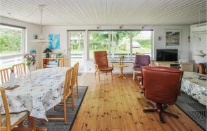 ein Esszimmer und ein Wohnzimmer mit einem Tisch und Stühlen in der Unterkunft Awesome Home In Sams With Wifi in Nordby