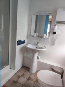 a bathroom with a sink and a toilet and a mirror at Les Galets Bleus in Étretat