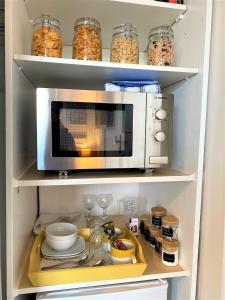 una cucina con forno a microonde e frigorifero di En-suite room, fridge microwave TV, great value homestay, near forest & sea a Lymington