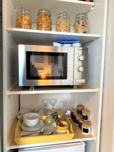 a kitchen with a microwave in a refrigerator at Cliftonville, en-suite room, fridge microwave TV, great value homestay near the sea in Lymington