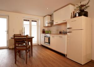 eine Küche mit einem Tisch und einem weißen Kühlschrank in der Unterkunft Ferienwohnung in alter Brauerei in Engelsberg
