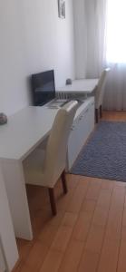 um escritório com duas secretárias com cadeiras e um computador portátil em Apartmani M em Mostar