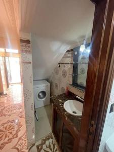 a small bathroom with a sink and a washing machine at Fully equipped ground floor apartment in Safi