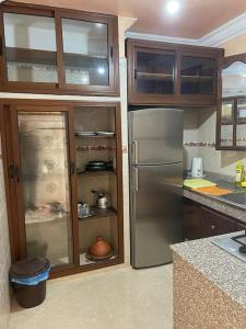 a kitchen with a stainless steel refrigerator and wooden cabinets at Fully equipped ground floor apartment in Safi