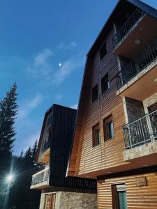 an apartment building with wooden siding and balconies at Vila Jelena in Jahorina