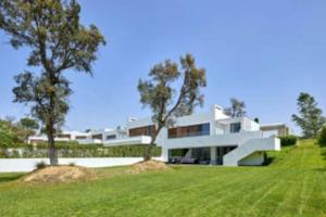 una grande casa bianca con alberi di fronte di Camiral Golf and Wellness Luxury Villa a Girona