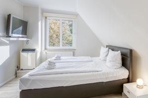 a bedroom with a large white bed with a window at Sunshine mit Kamin und Saunahaus in Alt Schwerin
