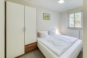 a bedroom with a white bed and a window at Sunshine mit Kamin und Saunahaus in Alt Schwerin
