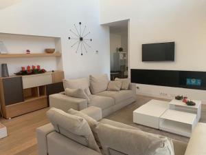 - un salon avec un canapé et une télévision dans l'établissement Camiral Golf and Wellness Luxury Villa, à Gérone