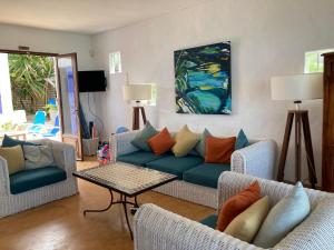 sala de estar con sofá azul y sillas en BlueMoon Villa on The Beach en Trou dʼ Eau Douce