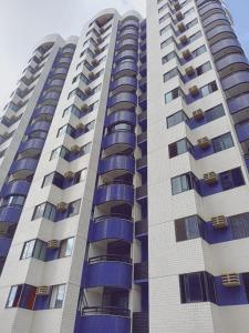 un edificio de apartamentos alto con balcones azules en BOA VIAGEM 2 quartos 100 m da praia até 5 pessoas, en Recife