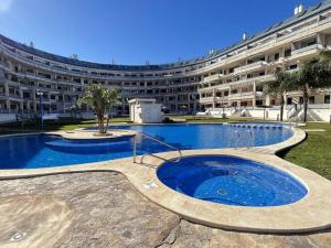 a large building with a swimming pool in front of a building at Sueños del Mar 1 By Alquileres El Conserje in Denia