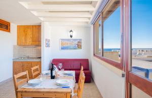 una sala da pranzo con tavolo e vista sull'oceano di Istoral Apartment Leuca a Leuca
