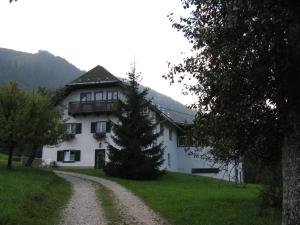 una casa con un albero di fronte a una strada sterrata di Haus Rottenstein a Neukirchen