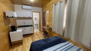 um pequeno quarto com uma cama e uma cozinha em Lindos e novos Chalés na região central de Foz em Foz do Iguaçu mais 14 fotografias