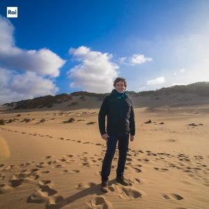 un hombre parado en la arena en el desierto en La Quercia, en Arbus