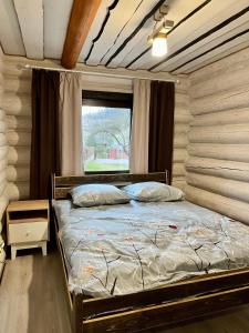 een bed in een kamer met een raam en een bed sidx sidx sidx bij Карпатська садиба in Plavie