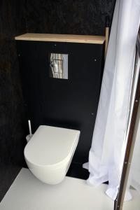 LE 12 في Ébreuil: مرحاض أبيض في غرفة سوداء مع ستارة
