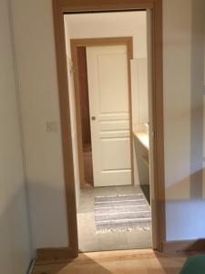 a hallway with a white door and a mirror at Cabane Chic au Cap Ferret in Lège-Cap-Ferret