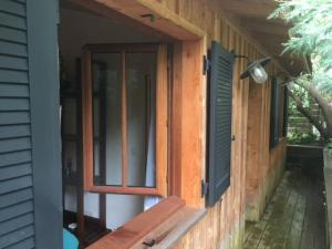 una ventana en el lateral de una casa con un banco en Cabane Chic au Cap Ferret, en Lège-Cap-Ferret