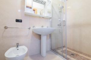 bagno con lavandino e doccia in vetro di Istoral Apartment Leuca a Leuca