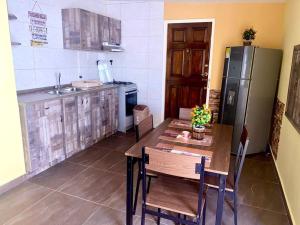 een keuken met een houten tafel en een koelkast bij Centrally located, private, 1 bedroom apartment. in Willemstad