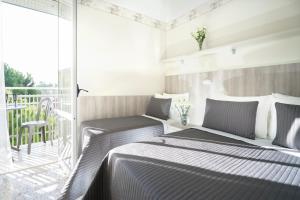 a bedroom with two beds and a balcony at Hotel Sampaoli in Bellaria-Igea Marina