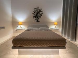 a bedroom with a large bed with two lamps at Artemisia Apartment Caldera in Imerovigli