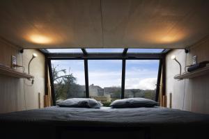 a bedroom with a bed with a large window at LE 12 in Ébreuil