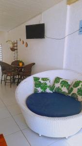 a white chair with a blue cushion in a living room at Casa com piscina em Carapibus - Jacumã in Conde