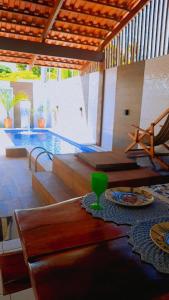 uma sala de estar com uma mesa e uma piscina em Casa com piscina em Carapibus - Jacumã em Conde