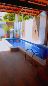 a swimming pool with two chairs next to it at Casa com piscina em Carapibus - Jacumã in Conde